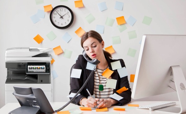 woman with post-its busy at desk with mfp in background