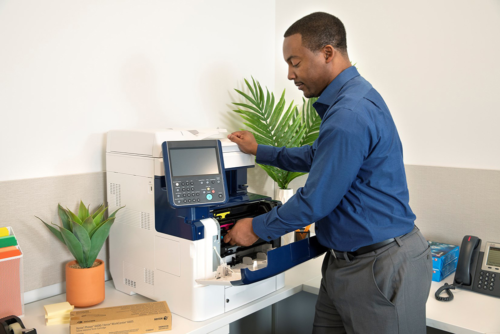 Man changing toner in printer