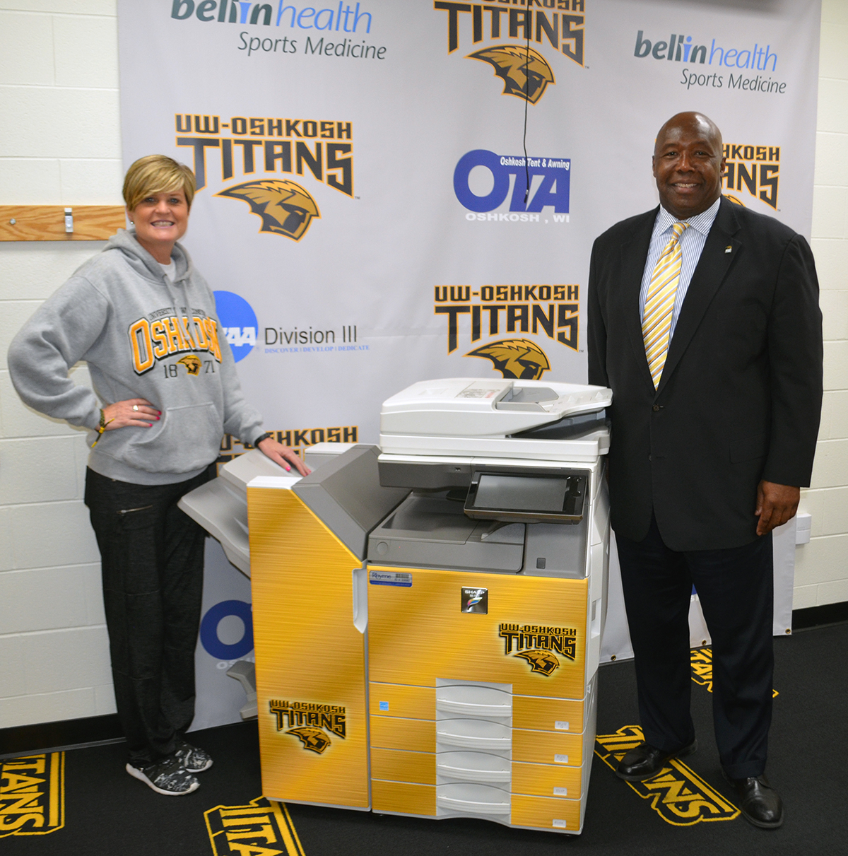 UW-Oshkosh Athletic Department Staff Poses next to MFP sold by Rhyme